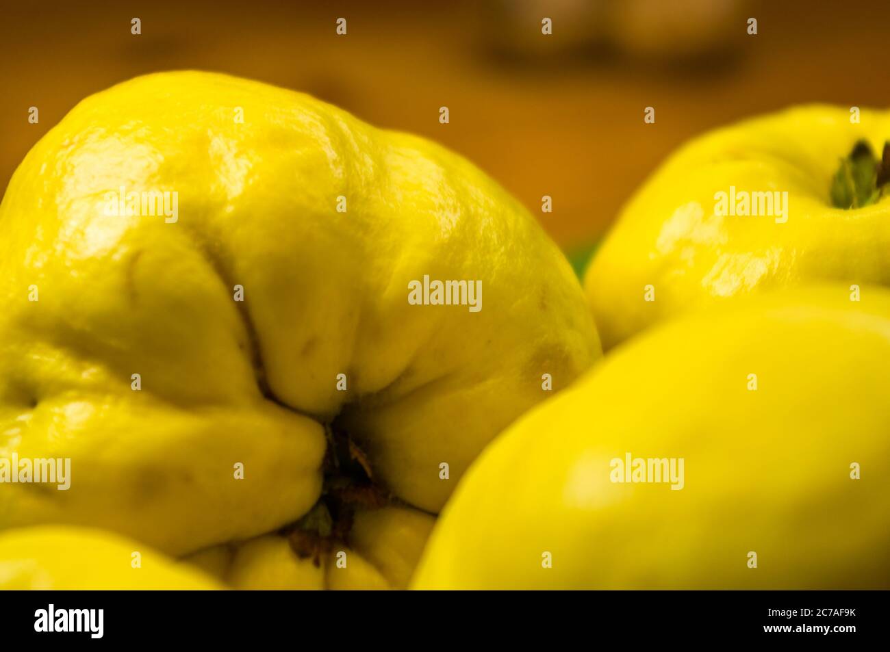 Große gelbe Quinzfrüchte auf einer Keramikplatte mit Anis, Zimt und Walnüssen Stockfoto
