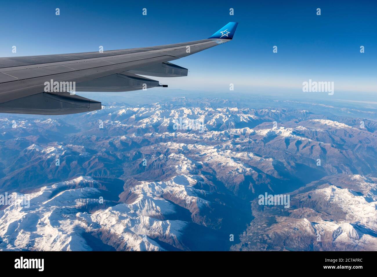 Flugreise, Tageszeit Luftaufnahme der französischen Alpen, französisch-italienische Grenze mit Blick aus dem Flugzeugfenster, Air Transat Flugzeugfenster Stockfoto