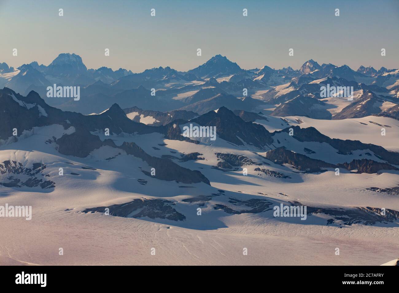 Weitläufige Aussicht aus der Vogelperspektive auf Alaskas schneebedeckte Bergketten und Gletschertäler, die die unberührte und raue Schönheit der arktischen Wildnis zeigen Stockfoto