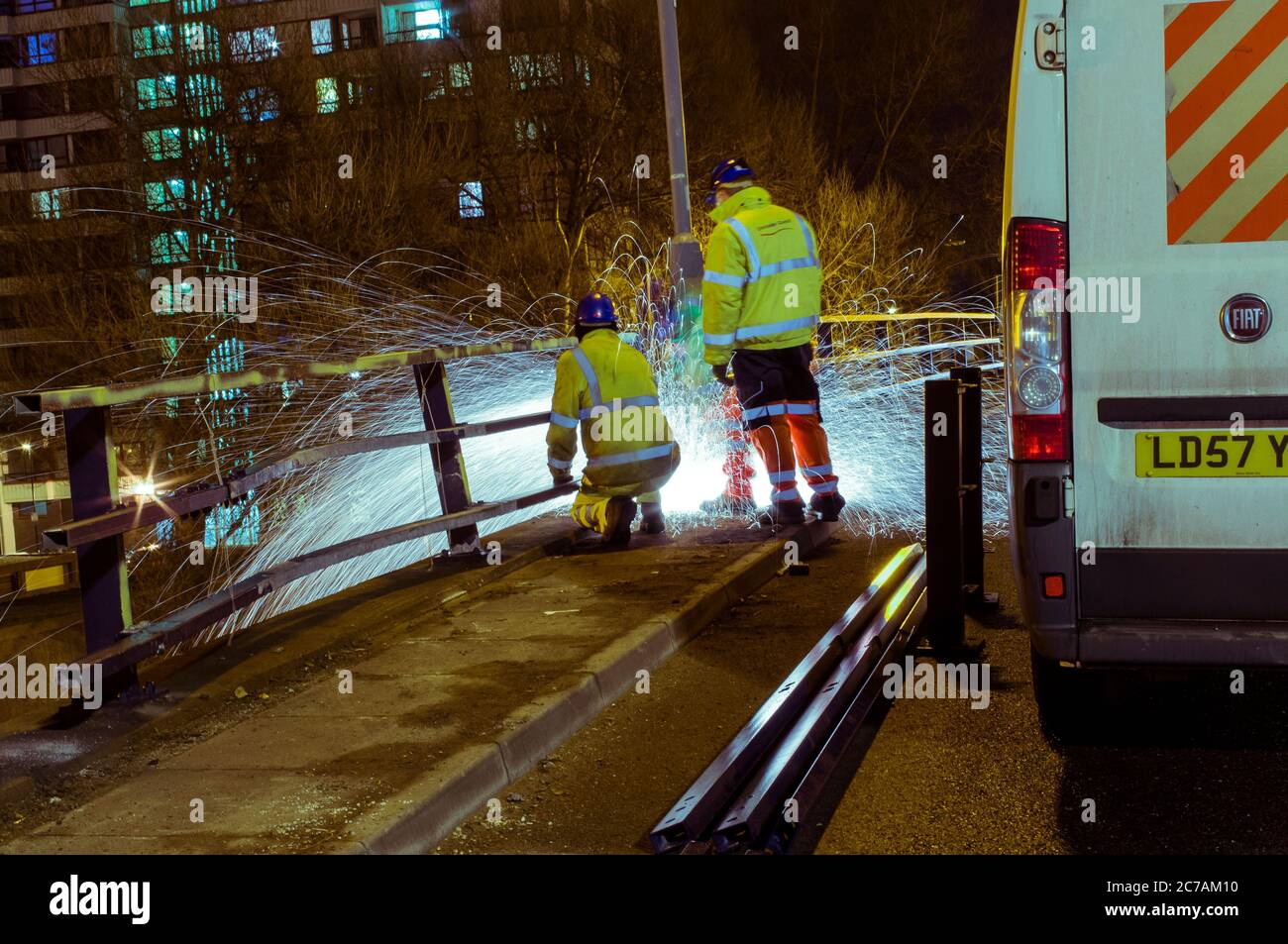 Straßenpersonal in der Nachtschicht, das an der Brücke arbeitet Stockfoto