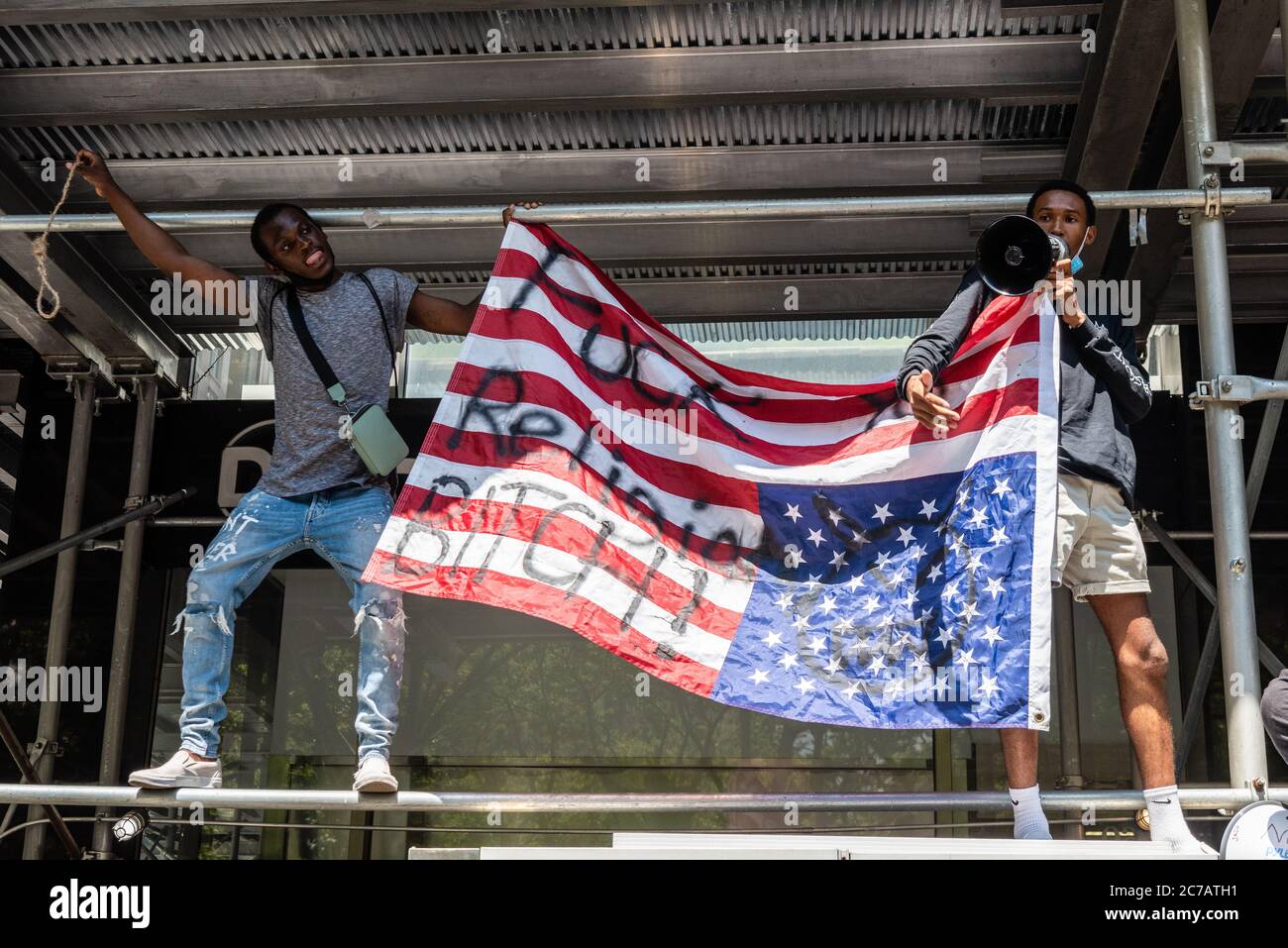 Brooklyn, New York, USA. Juli 2020. Zwei Black Lives Matter Aktivisten halten eine verstellte amerikanische Flagge auf den Kopf, während einer eine Schlinge hält, die vorgibt, gehängt zu werden, während Geistliche und Anhänger der Strafverfolgung sich zur "Power of Prayer"-Kundgebung versammeln, die am Juli ein Ende der Gewalt vor dem Rathaus in New York City fordert 15, 2020. (Foto von Gabriele Holtermann/Sipa USA) Quelle: SIPA USA/Alamy Live News Stockfoto