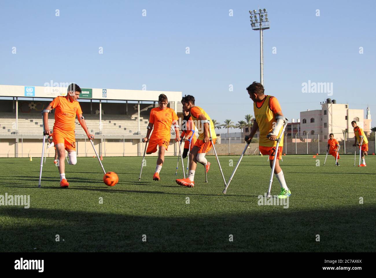 Gaza. Juli 2020. Palästinensische Amputeekinder nehmen an einem Fußballtraining Teil, das vom palästinensischen Amputeefußballverband in Zusammenarbeit mit dem Internationalen Komitee vom Roten Kreuz (IKRK) im al-Durra-Stadion in Deir al-Balah, im zentralen Gazastreifen, am 14. Juli 2020 organisiert wird. Voller Tatendrang nahm eine Gruppe von 26 Amputierten-Kindern das wöchentliche Fußballtraining wieder auf, nachdem sie drei Monate lang aufgrund der Sperre der blockierten Küstenenklave inmitten des wütenden COVID-19 ausgesetzt worden war. Kredit: Rizek Abdeljawad/Xinhua/Alamy Live Nachrichten Stockfoto