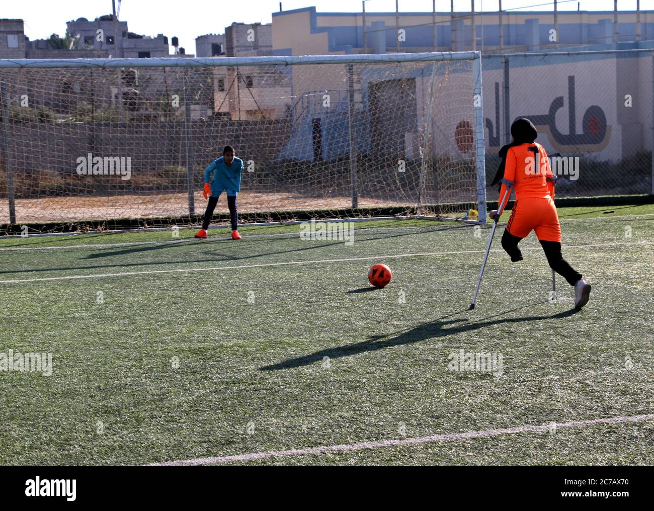 Gaza. Juli 2020. Ein palästinensisches Amputeemädchen nimmt an einem Fußballtraining Teil, das vom palästinensischen Amputeemafotivverband in Zusammenarbeit mit dem Internationalen Komitee vom Roten Kreuz (IKRK) im al-Durra-Stadion in Deir al-Balah, im zentralen Gazastreifen, am 14. Juli 2020 organisiert wird. Voller Tatendrang nahm eine Gruppe von 26 Amputierten-Kindern das wöchentliche Fußballtraining wieder auf, nachdem sie drei Monate lang aufgrund der Sperre der blockierten Küstenenklave inmitten des wütenden COVID-19 ausgesetzt worden war. Kredit: Rizek Abdeljawad/Xinhua/Alamy Live Nachrichten Stockfoto