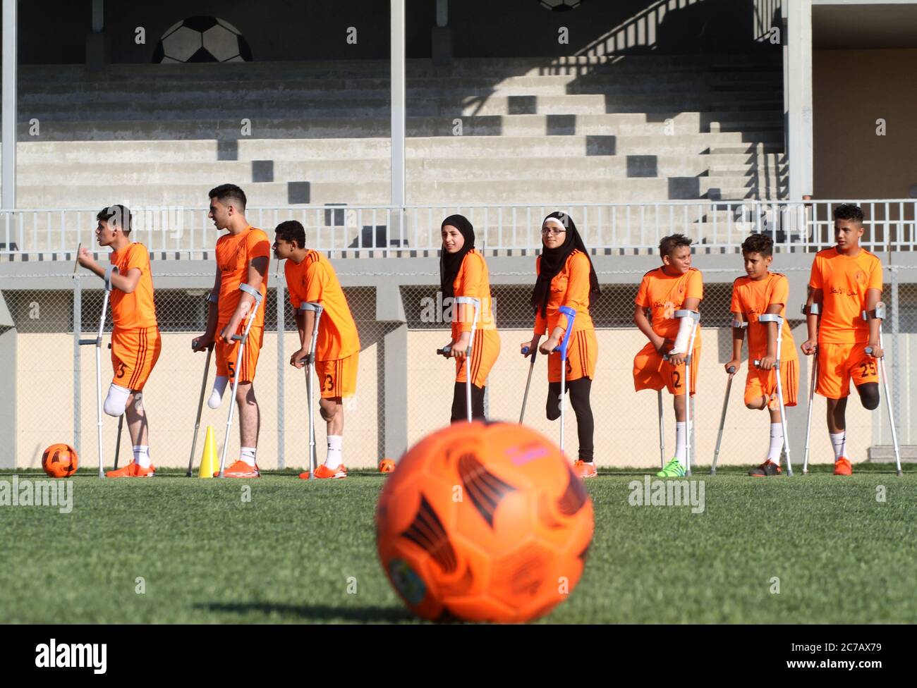 Gaza. Juli 2020. Palästinensische Amputeekinder nehmen an einem Fußballtraining Teil, das vom palästinensischen Amputeefußballverband in Zusammenarbeit mit dem Internationalen Komitee vom Roten Kreuz (IKRK) im al-Durra-Stadion in Deir al-Balah, im zentralen Gazastreifen, am 14. Juli 2020 organisiert wird. Voller Tatendrang nahm eine Gruppe von 26 Amputierten-Kindern das wöchentliche Fußballtraining wieder auf, nachdem sie drei Monate lang aufgrund der Sperre der blockierten Küstenenklave inmitten des wütenden COVID-19 ausgesetzt worden war. Kredit: Rizek Abdeljawad/Xinhua/Alamy Live Nachrichten Stockfoto