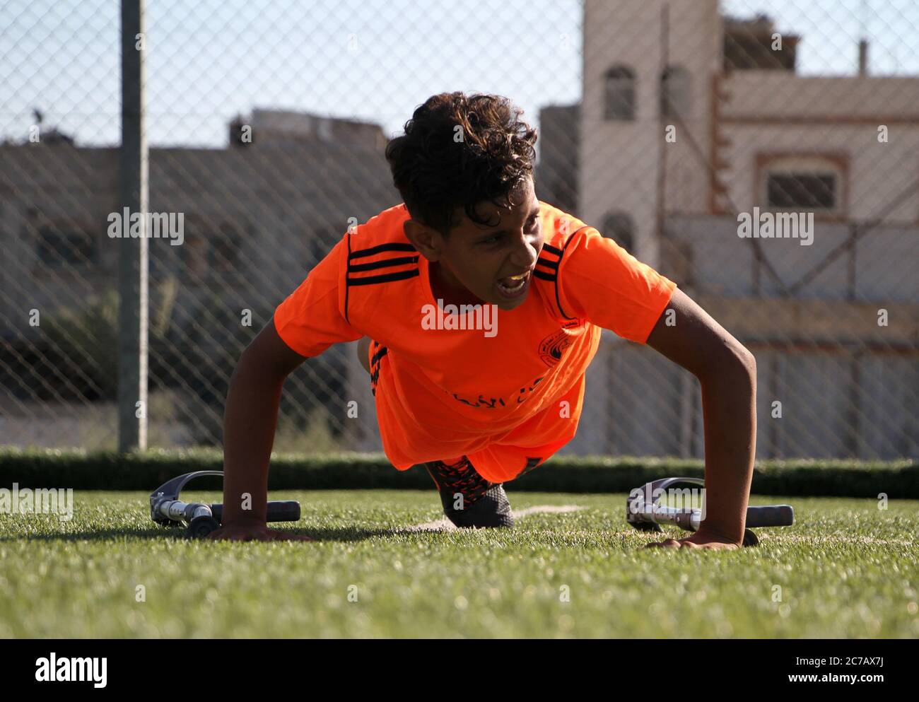 Gaza. Juli 2020. Ein palästinensischer Amputeenjunge nimmt an einem Fußballtraining Teil, das vom palästinensischen Amputeenverband in Zusammenarbeit mit dem Internationalen Komitee vom Roten Kreuz (IKRK) im al-Durra-Stadion in Deir al-Balah, im zentralen Gazastreifen, am 14. Juli 2020 organisiert wird. Voller Tatendrang nahm eine Gruppe von 26 Amputierten-Kindern das wöchentliche Fußballtraining wieder auf, nachdem sie drei Monate lang aufgrund der Sperre der blockierten Küstenenklave inmitten des wütenden COVID-19 ausgesetzt worden war. Kredit: Rizek Abdeljawad/Xinhua/Alamy Live Nachrichten Stockfoto