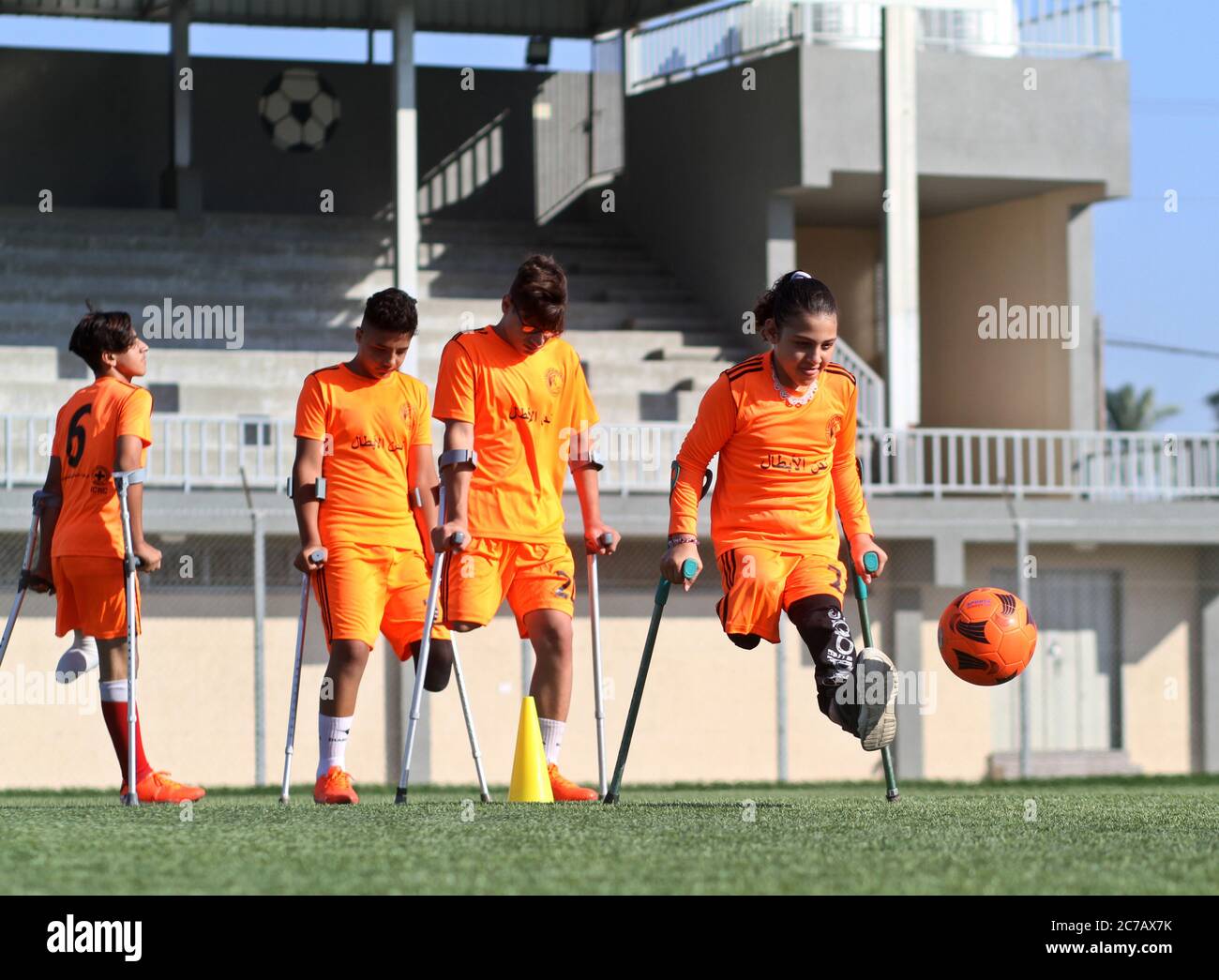 Gaza. Juli 2020. Palästinensische Amputeekinder nehmen an einem Fußballtraining Teil, das vom palästinensischen Amputeefußballverband in Zusammenarbeit mit dem Internationalen Komitee vom Roten Kreuz (IKRK) im al-Durra-Stadion in Deir al-Balah, im zentralen Gazastreifen, am 14. Juli 2020 organisiert wird. Voller Tatendrang nahm eine Gruppe von 26 Amputierten-Kindern das wöchentliche Fußballtraining wieder auf, nachdem sie drei Monate lang aufgrund der Sperre der blockierten Küstenenklave inmitten des wütenden COVID-19 ausgesetzt worden war. Kredit: Rizek Abdeljawad/Xinhua/Alamy Live Nachrichten Stockfoto