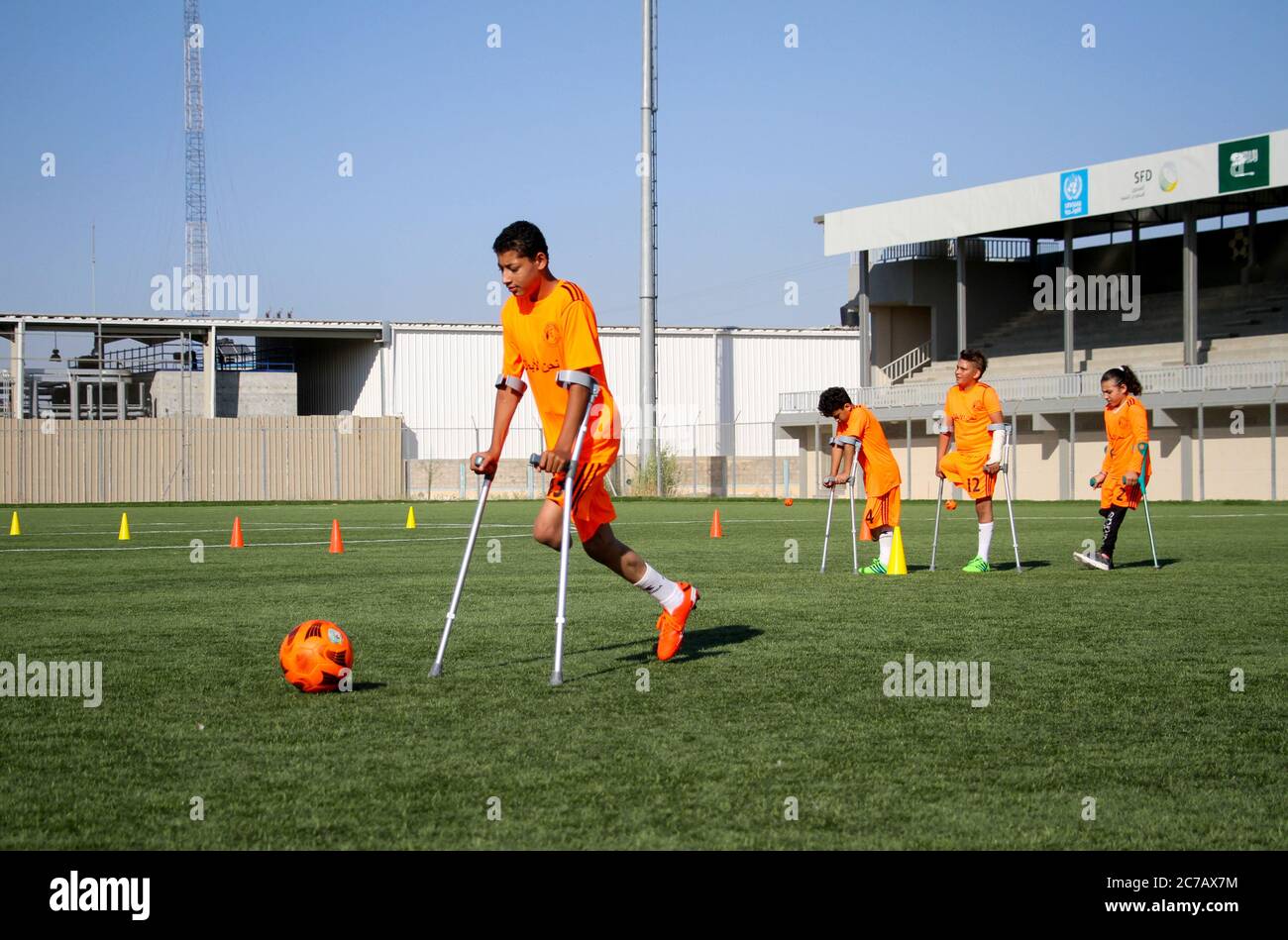 Gaza. Juli 2020. Palästinensische Amputeekinder nehmen an einem Fußballtraining Teil, das vom palästinensischen Amputeefußballverband in Zusammenarbeit mit dem Internationalen Komitee vom Roten Kreuz (IKRK) im al-Durra-Stadion in Deir al-Balah, im zentralen Gazastreifen, am 14. Juli 2020 organisiert wird. Voller Tatendrang nahm eine Gruppe von 26 Amputierten-Kindern das wöchentliche Fußballtraining wieder auf, nachdem sie drei Monate lang aufgrund der Sperre der blockierten Küstenenklave inmitten des wütenden COVID-19 ausgesetzt worden war. Kredit: Rizek Abdeljawad/Xinhua/Alamy Live Nachrichten Stockfoto