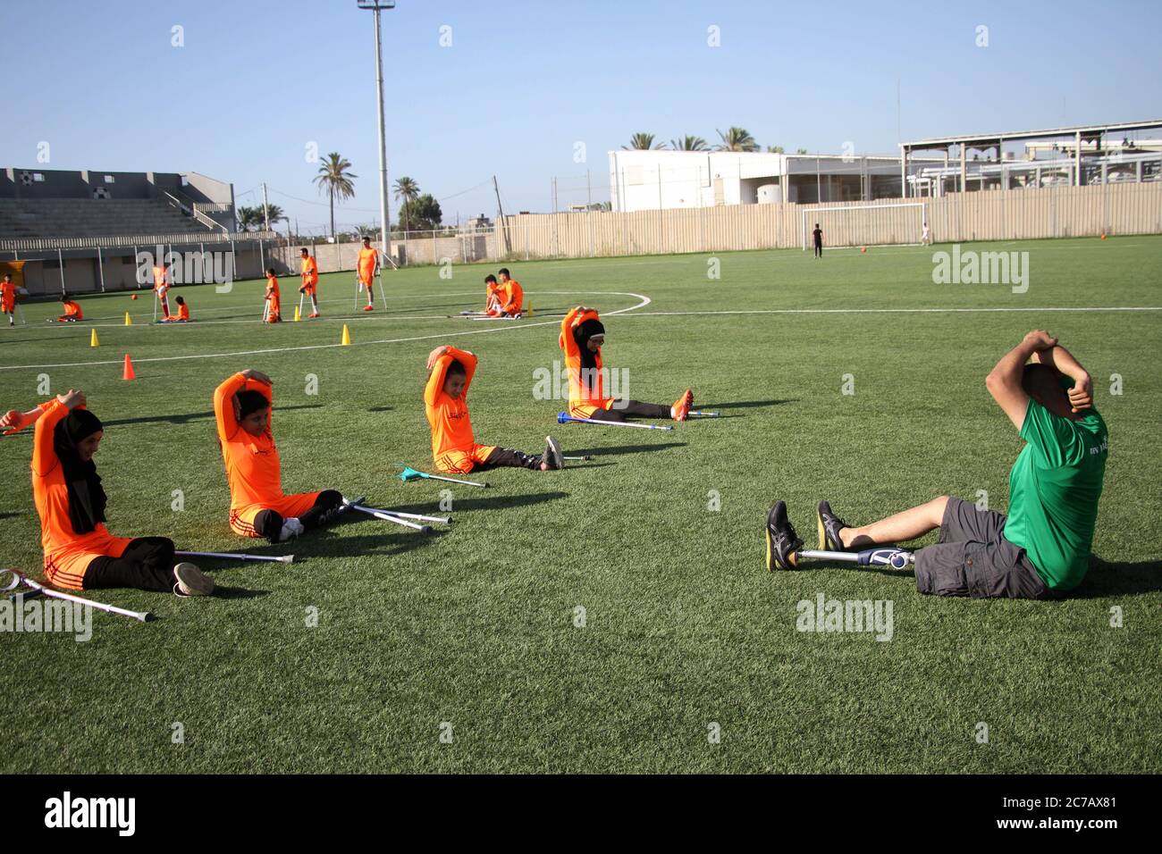 Gaza. Juli 2020. Palästinensische Amputeekinder nehmen an einem Fußballtraining Teil, das vom palästinensischen Amputeefußballverband in Zusammenarbeit mit dem Internationalen Komitee vom Roten Kreuz (IKRK) im al-Durra-Stadion in Deir al-Balah, im zentralen Gazastreifen, am 14. Juli 2020 organisiert wird. Voller Tatendrang nahm eine Gruppe von 26 Amputierten-Kindern das wöchentliche Fußballtraining wieder auf, nachdem sie drei Monate lang aufgrund der Sperre der blockierten Küstenenklave inmitten des wütenden COVID-19 ausgesetzt worden war. Kredit: Rizek Abdeljawad/Xinhua/Alamy Live Nachrichten Stockfoto