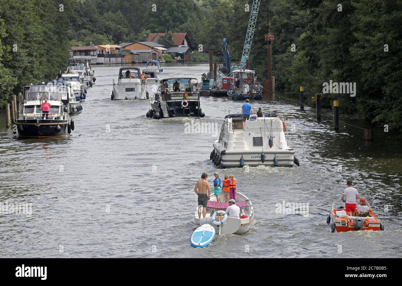 Mirow, Deutschland. Juli 2020. Urlauber sind mit ihren Booten vor der Schleuse auf dem Mirower Kanal. Die Boote auf der linken Seite warten darauf, in die Schleuse zu gelangen, die auch als "Tor zur Müritz" bekannt ist. Aufgrund der Corona-Krise hat die Tourismusbranche in der Mecklenburgischen Seenplatte deutlich mehr Anfragen, hat aber immer noch Übernachtungsmöglichkeiten. Es fehlt an den kurzentschlossen entschlossenen Tagestouristen, die noch nicht wahrscheinlich in den Nordosten kommen. Quelle: Bernd Wüstneck/dpa-Zentralbild/dpa/Alamy Live News Stockfoto