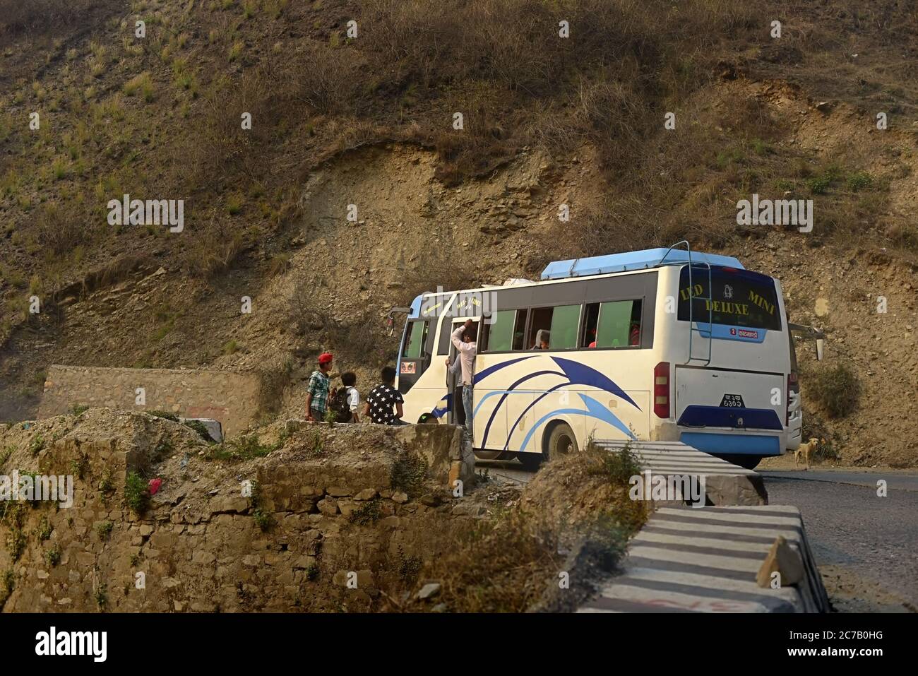 Ein Bus, der Passagiere auf einer Straße abholt, die Pokhara und Kathmandu verbindet – ein Teil von Nepals Strategic Road Network (SRN) –, die an einem steilen Hang am Rande des Kathmandu-Tals, am Stadtrand von Kathmandu City, Nepal, liegt. Archivfoto (2016). Das Straßennetz in Nepal erlitt durch das Erdbeben von 2015 mäßige Schäden. Die geschätzten Schäden für das strategische Straßennetz (SRN) betrugten 45.9 Millionen US-Dollar, während die Gesamtverluste bei 5.26 Millionen US-Dollar lagen. Auf dem lokalen Straßennetz (LRN) betrug der geschätzte Gesamtschäden 124.85 Millionen USD, während der Gesamtschäden 42.74 Millionen USD betrug. Stockfoto