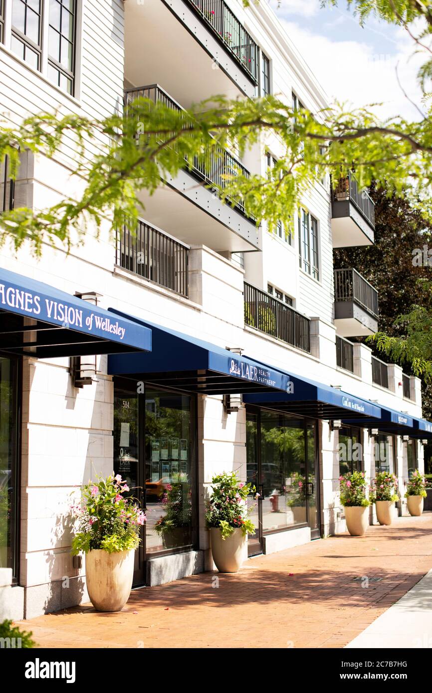 Ein gemischtes Gebäude mit Geschäften und Boutiquen mit Apartments in den oberen Etagen der Washington Street in Wellesley, Massachusetts, USA. Stockfoto