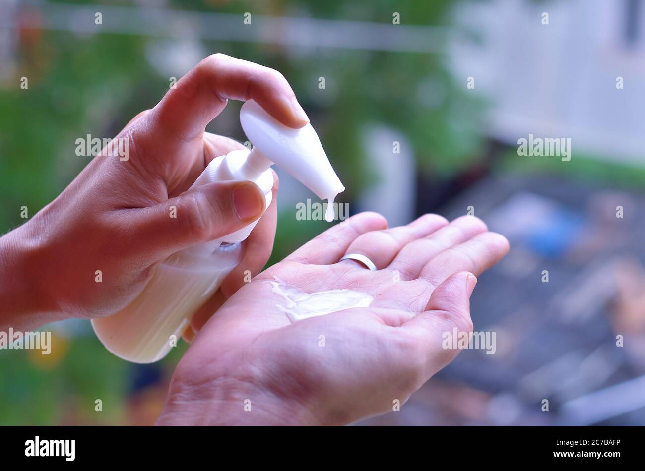 Frau, die Hände mit einem Handdesinfektionsmittel reinigt, um sich vor covid-19 zu schützen Stockfoto