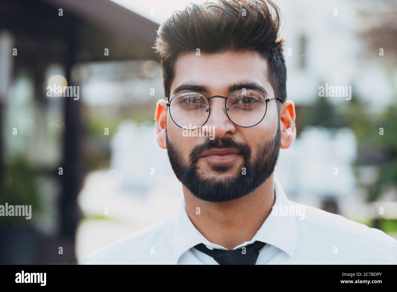 Stilvoll gekleideter indischer Bärtiger geht die Straße hinunter. Stockfoto