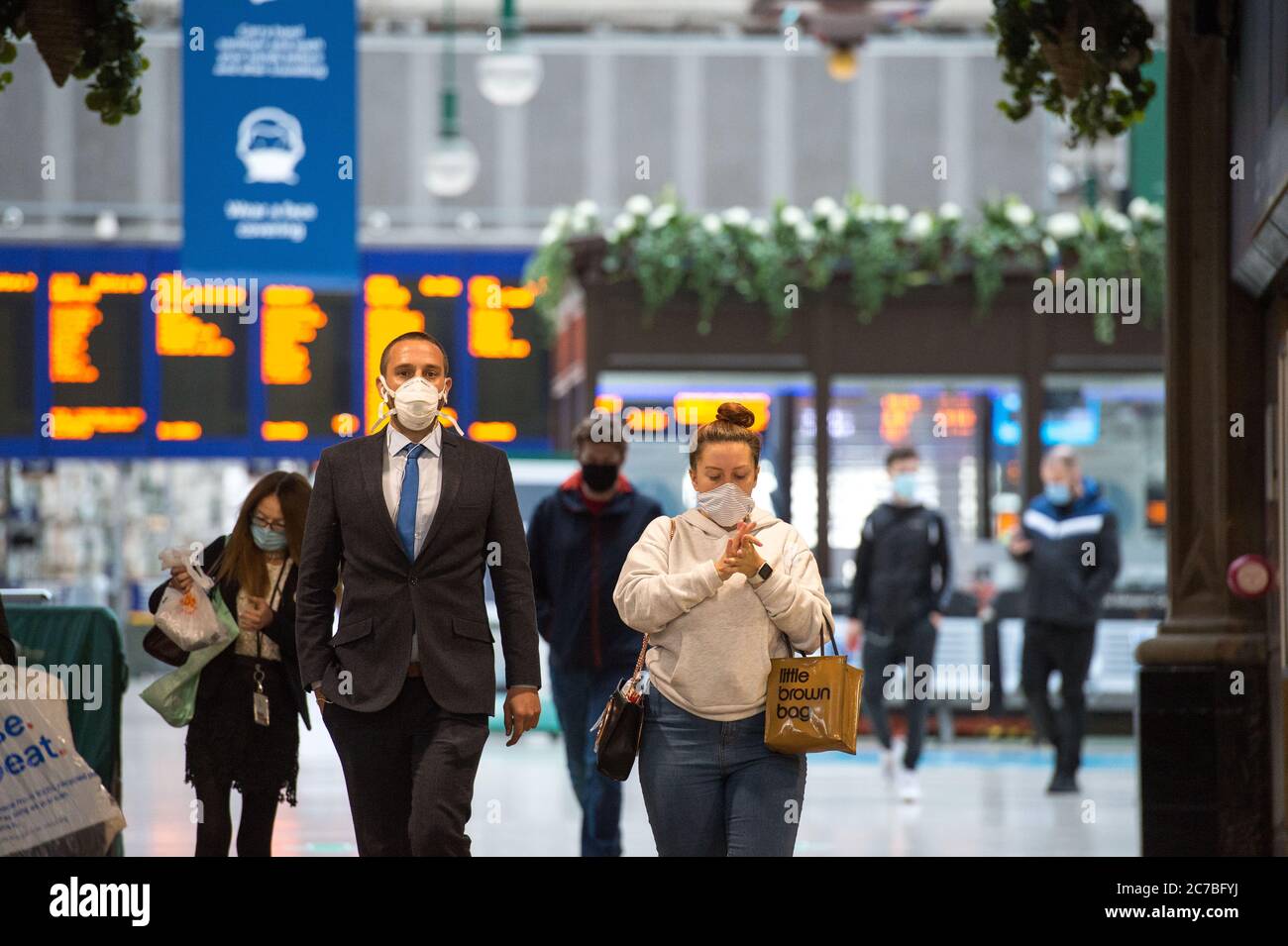 Glasgow, Schottland, Großbritannien. Juli 2020. Im Bild: Menschen mit Gesichtsmasken und Gesichtsbezügen während ihrer täglichen Zugfahrt zum Hauptbahnhof im Stadtzentrum. Die schottische Regierung hat es zur Pflicht gemacht, dass Gesichtsbezüge bei Reisen mit öffentlichen Verkehrsmitteln in Schottland getragen werden, um die Ausbreitung des Coronavirus zu verhindern. Quelle: Colin Fisher/Alamy Live News Stockfoto