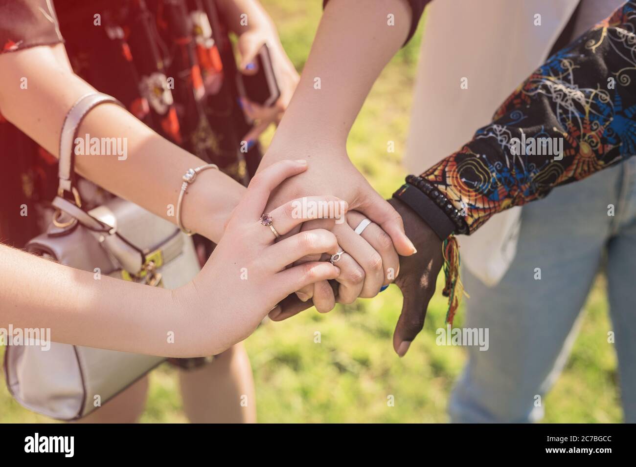 Nahaufnahme der Ansicht von oben, dass junge Menschen mit unterschiedlichen Nationalitäten die Hände zusammenlegen. Stapel von Freunden Hände. Stockfoto