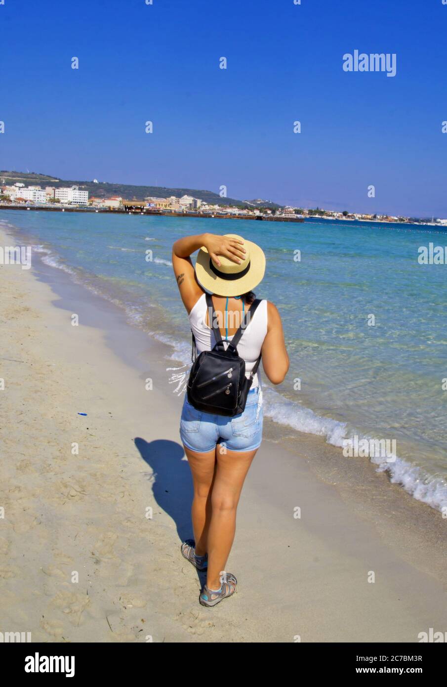 Schöne junge Frau im Hut am Strand Stockfoto