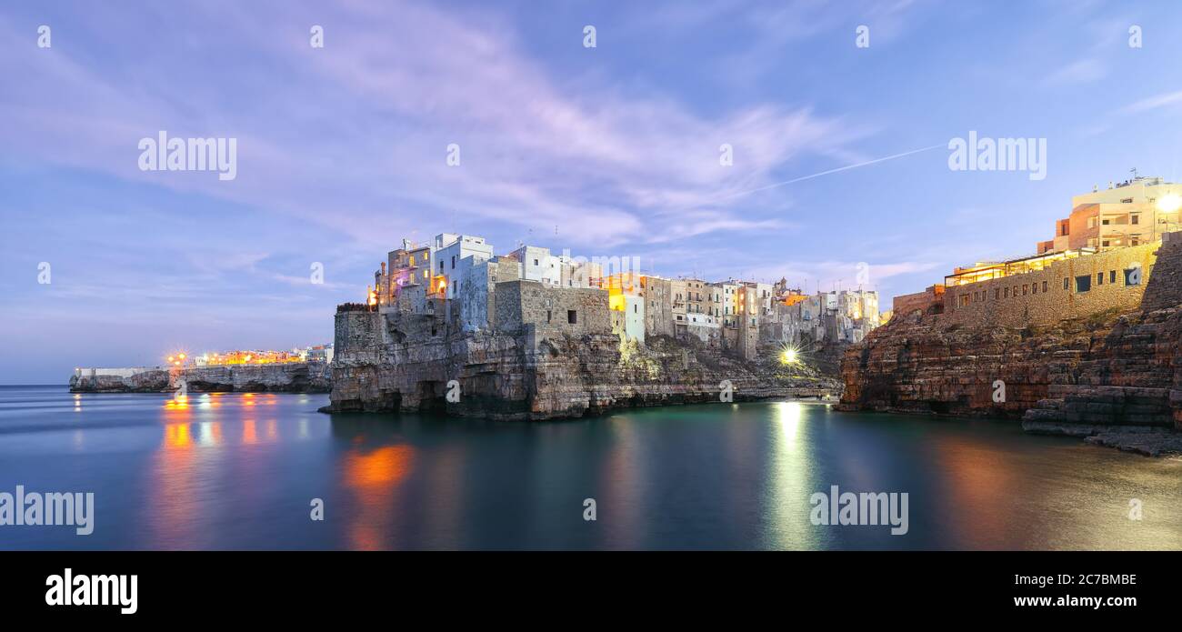 Sonnenuntergang am Cala Paura Golf mit Bastione di Santo Stefano im Dorf auf den Felsen Polignano a Mare, Apulien, Italien, Provinz Bari. Stockfoto