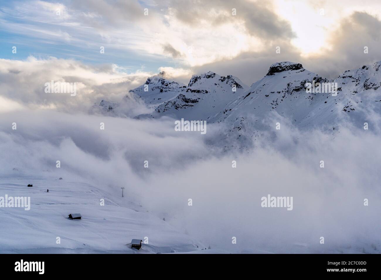 Sonnenuntergang über dem schneebedeckten Pordoi-Pass, wolkenbedeckte Sicht, Dolomiten, Trentino-Südtirol, Italien Stockfoto