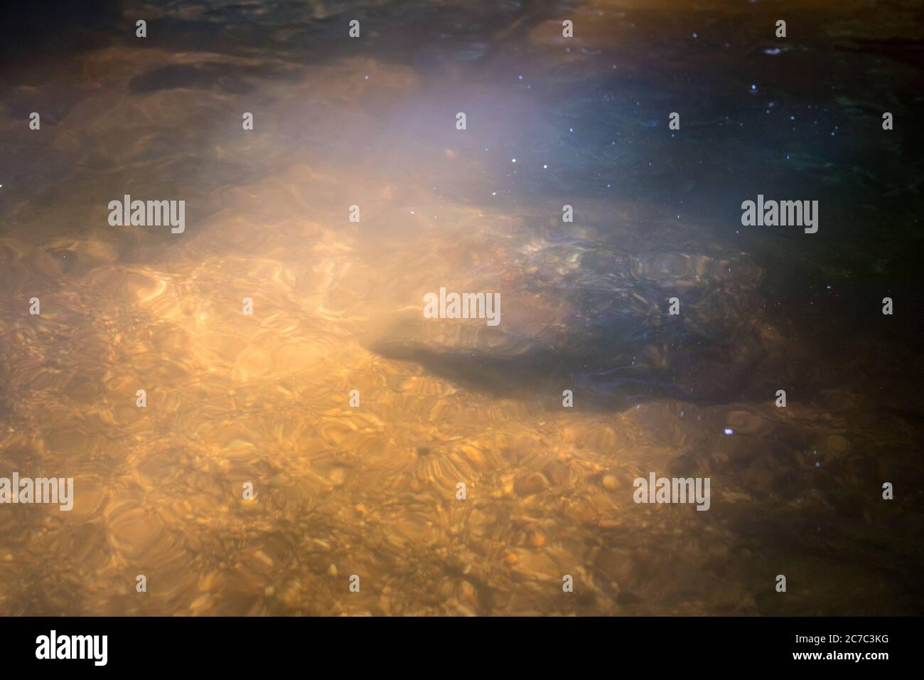 Wasseroberfläche von der Sonne beleuchtet, klares Wasser und sandigen Boden Stockfoto