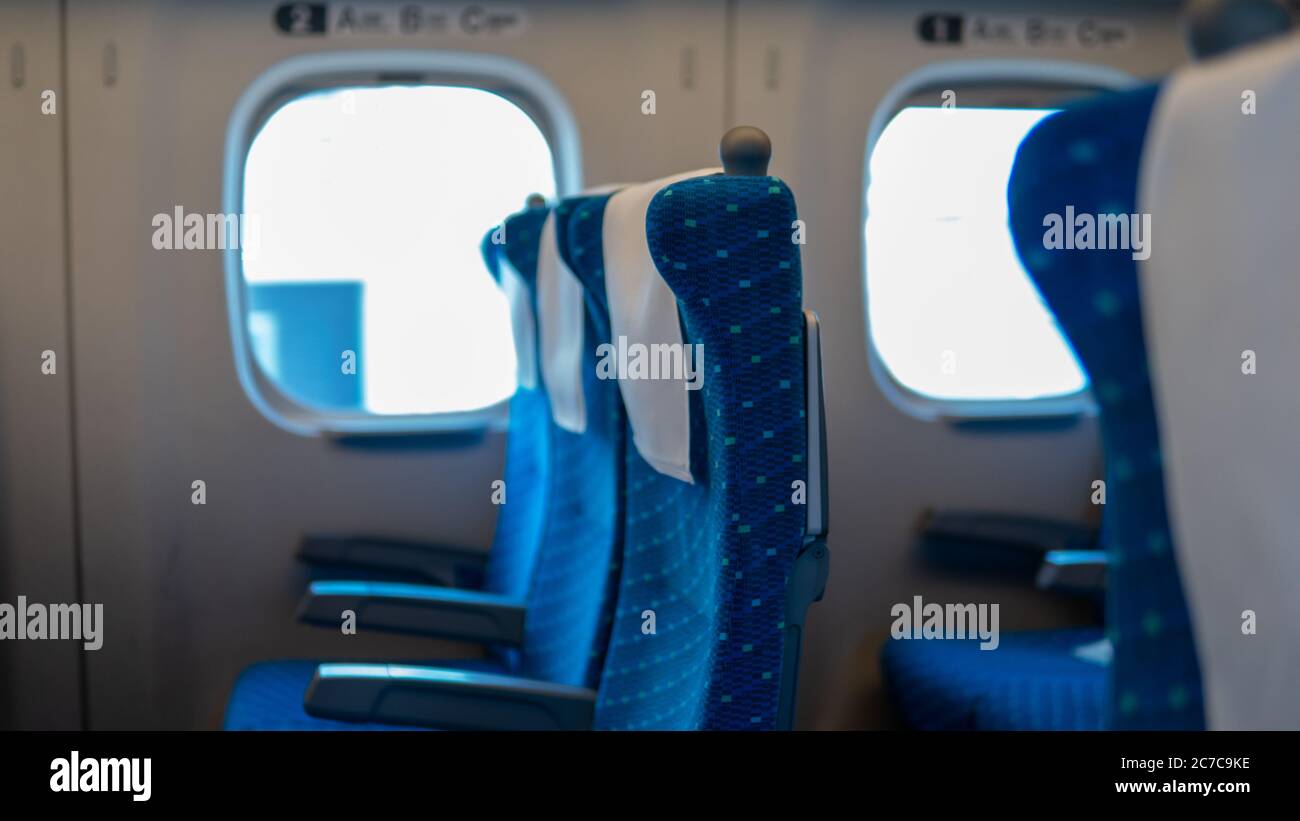 Leere Sitze im Pendlerzug in Japan, der von Osaka nach Tokio fährt, aufgrund von Covid-19-Reisebeschränkungen weniger Passagiere, blaue Sitze, Schnellzug. Mittel Stockfoto