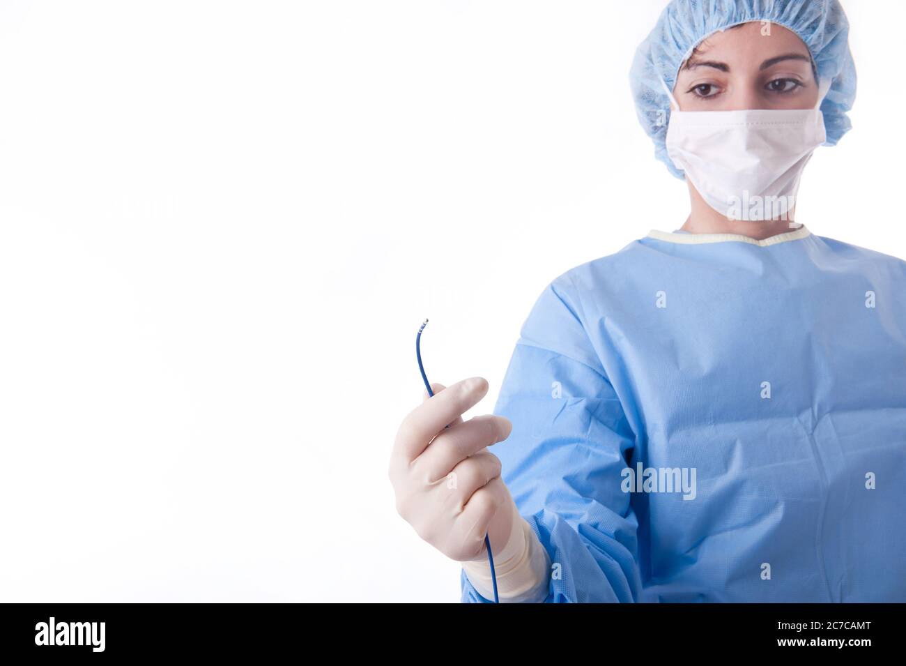 Ärztin oder Krankenschwester, die einen blauen sterilen Anzug oder einen blauen Kittel mit Ablationskatheter für einen Herzvorgang trägt. Den Katheter fokussieren Stockfoto