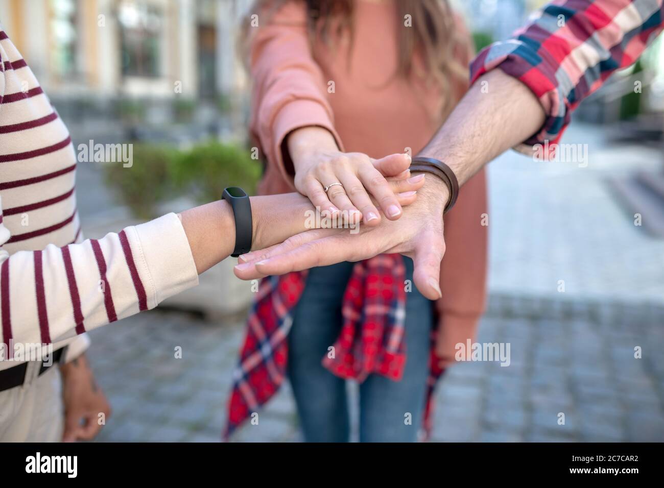 Männliche Hand und zwei weibliche Gesten zeigen Treue zur Freundschaft Stockfoto