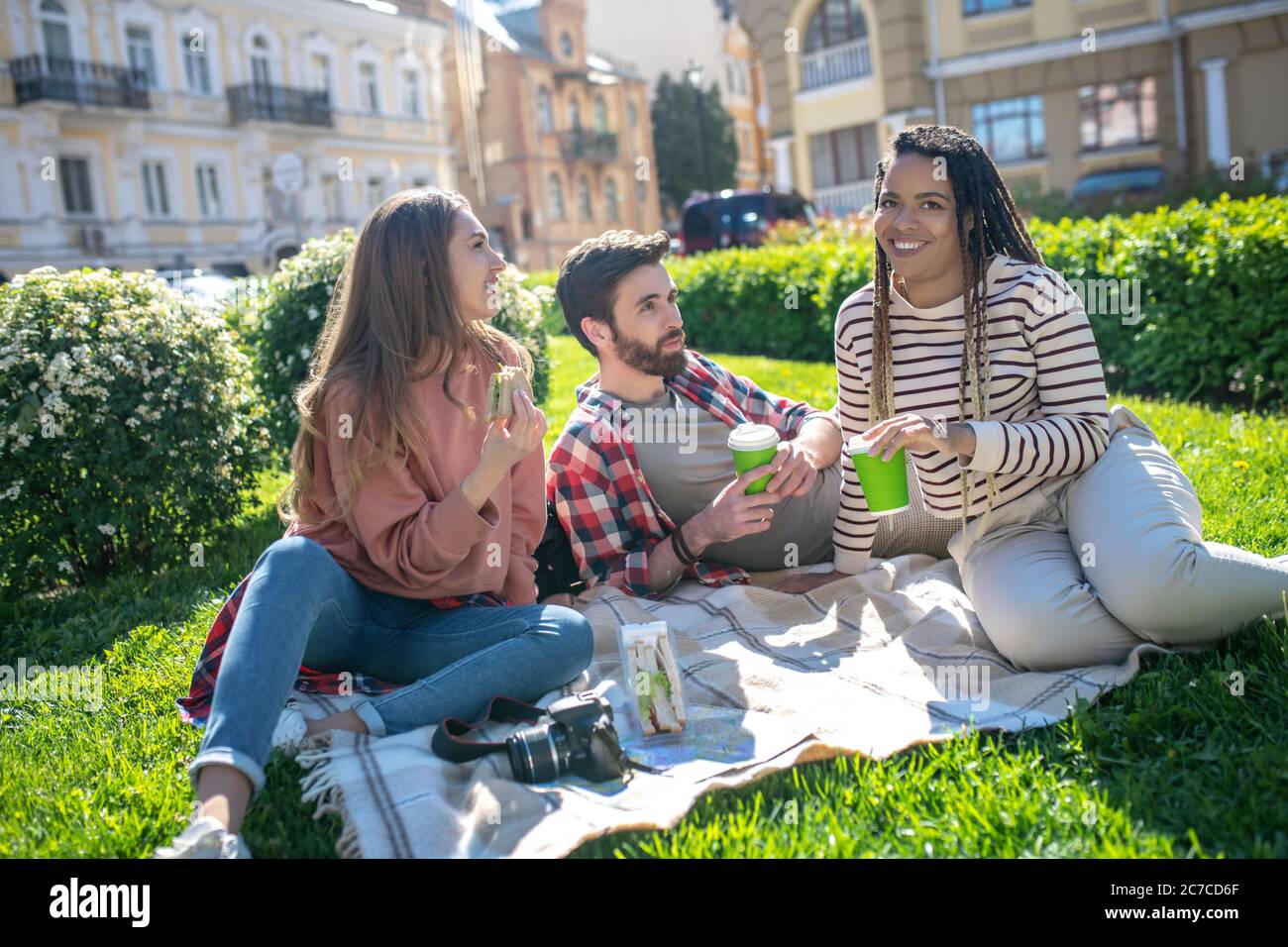 Drei Freunde auf Picknick auf einem Stadtplatz Stockfoto