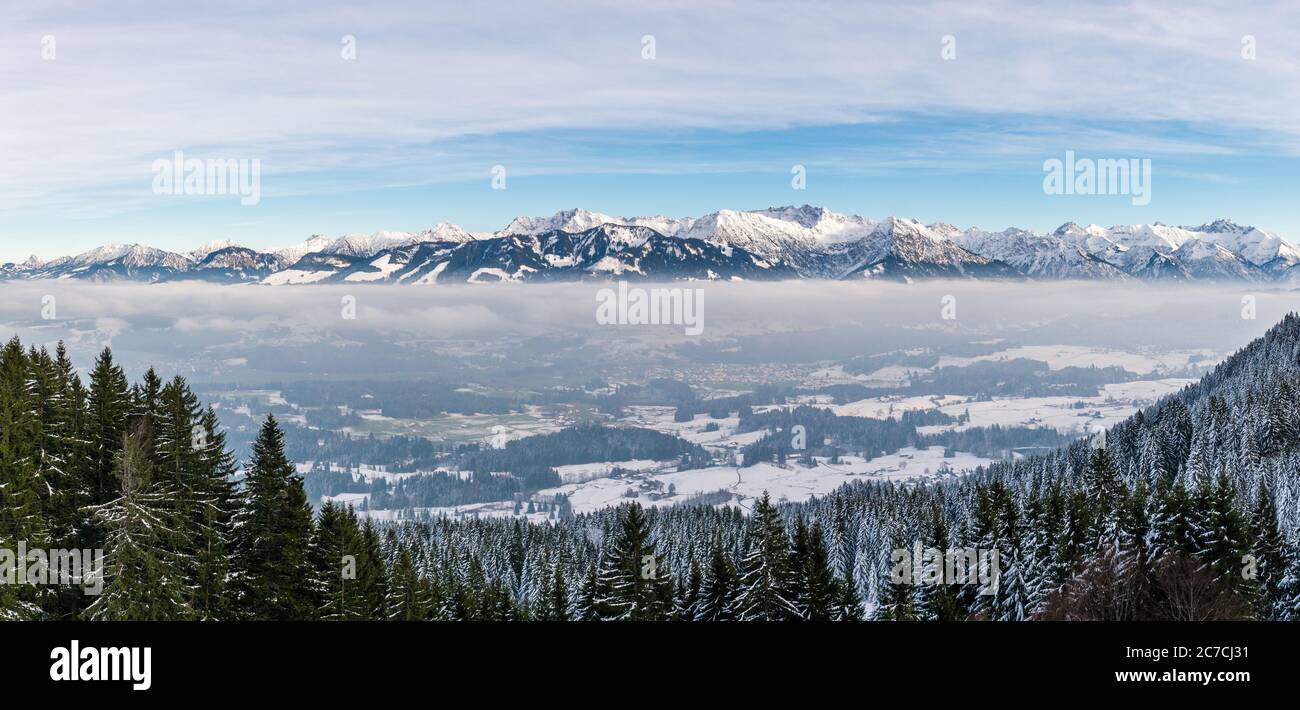 Herrlicher Panoramablick auf verschneite Berge über nebligen Wolkenschichten. Blick vom Rangiswangerhorn nach Illertal, Allgau, Bayern, Deutschland. Stockfoto