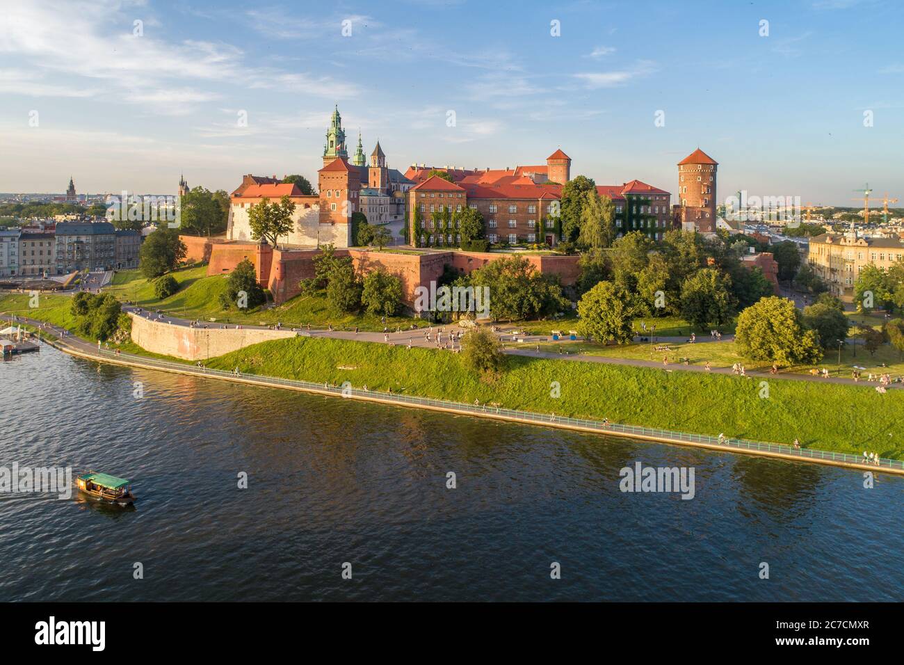 Königliche Wawel-Kathedrale und Schloss in Krakau, Polen. Luftaufnahme bei Sonnenuntergang. Weichsel, Touristenboot, Flussufer mit Park. Promenade und Spaziergang Stockfoto