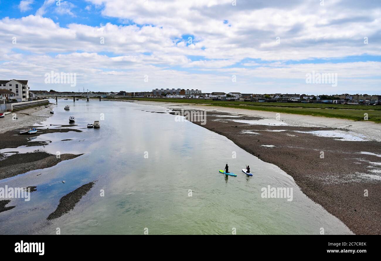 Brighton UK 16. Juli 2020 - Paddlebarder fahren entlang des Flusses Adur in Shoreham bei Brighton an einem warmen Tag in der Nähe von Brighton, da wärmeres sonniges Wetter für später in der Woche und am Wochenende in ganz Großbritannien prognostiziert wird : Credit Simon Dack / Alamy Live News Stockfoto