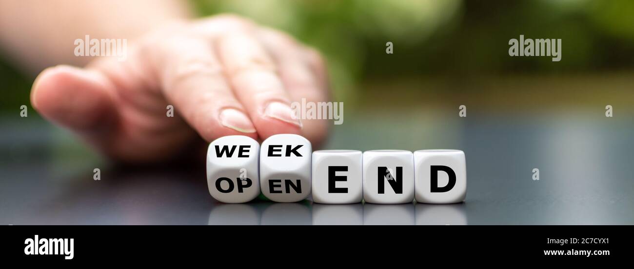Hand dreht Würfel und ändert den Ausdruck 'open-end' zu 'weekend'. Stockfoto