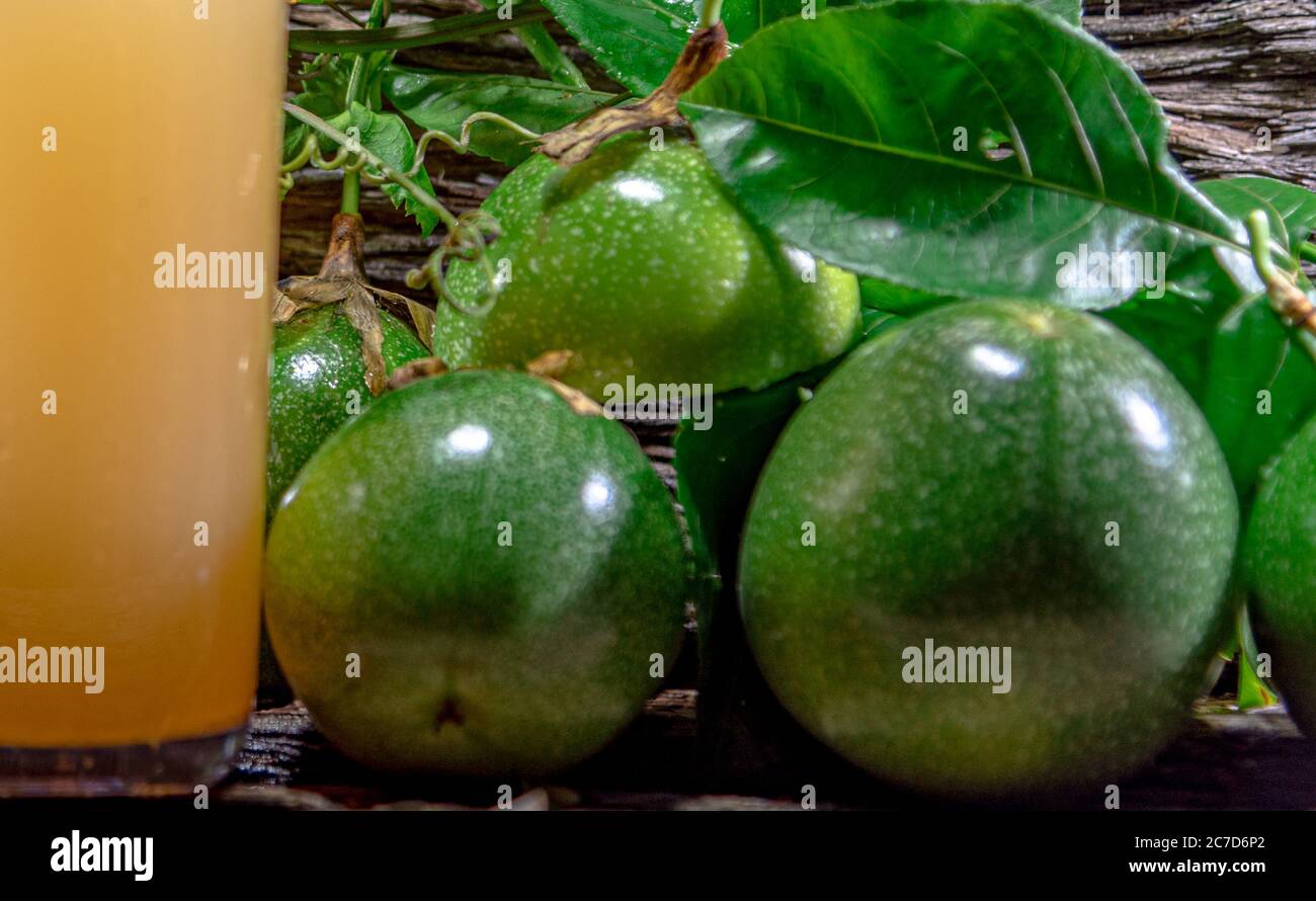 Frischer und gefrorener Passionsfruchtsaft. Grüne Früchte. Blätter auf Holzgrund. Gesundes Getränk. Tropischer Fruchtcocktail. Erfrischendes Getränk. Natürliches dri Stockfoto