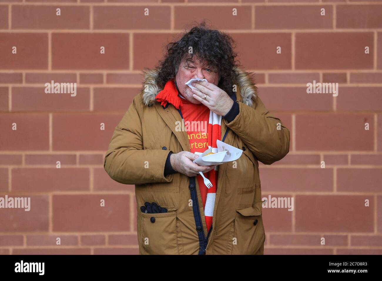 Ein Liverpool-Fan isst vor dem Anpfiff Fisch und Chips Stockfoto