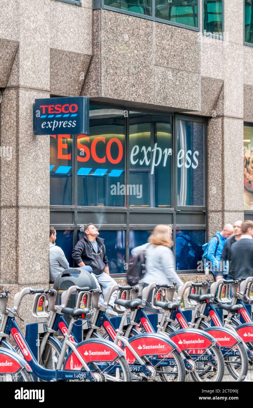 Santander Bikes vor einem Tesco Express Supermarkt. Stockfoto