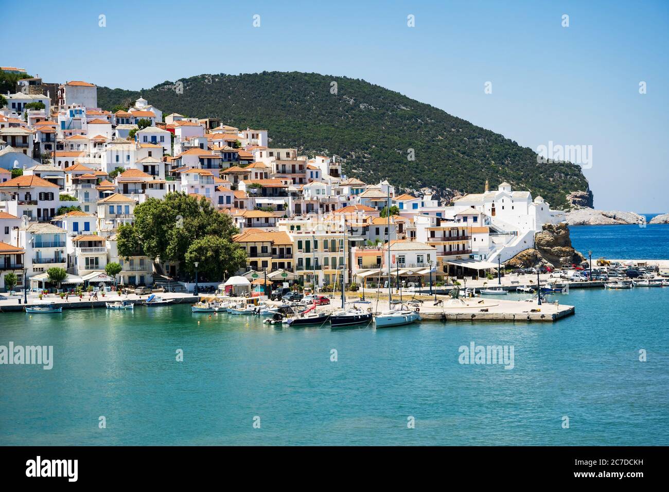 Die historische Stadt auf der Insel Skopelos vom Boot aus gesehen, wenn man im Sommerlicht in den Hafen einfährt. Stockfoto