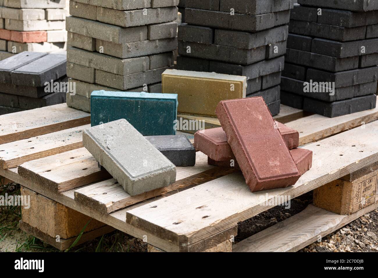 Verlegung von farbigen Betonplatten im Park. Professionelle Arbeiter Maurer installieren neue Fliesen und Pflasterplatten für Bürgersteig auf Ebenen s Stockfoto