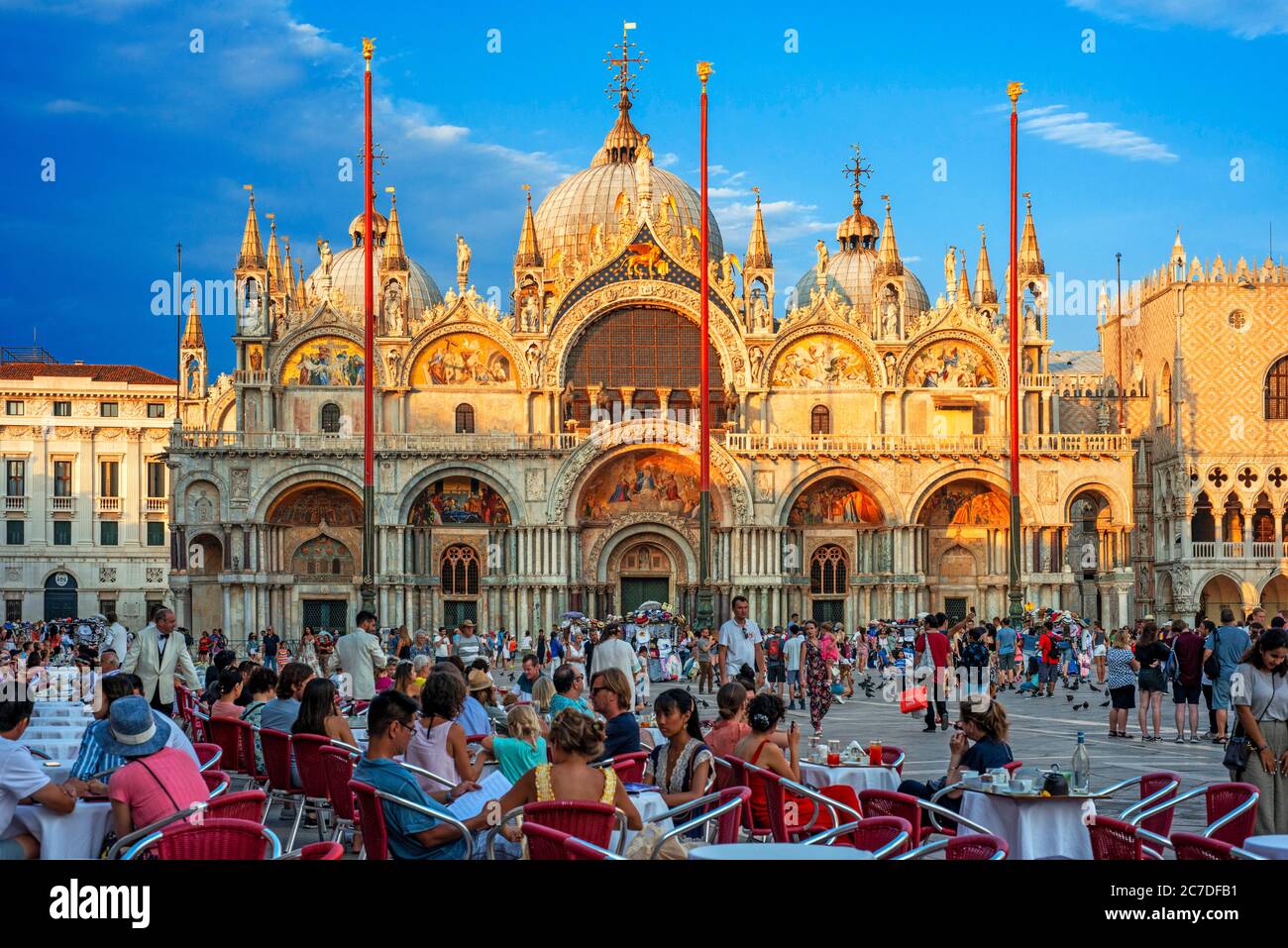 Basilica San Marco spiegelt sich in Acqua alta auf dem Piazza San Marco in der Dämmerung während Sonnenuntergang, Venedig, Italien mit Bewegung verschwimmen auf die Massen von Touristen Stockfoto