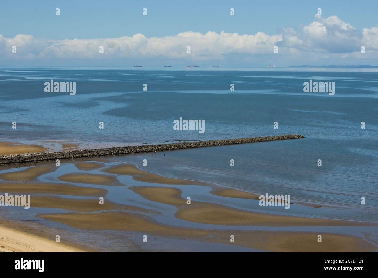 Ein langer Pier, der sich in die ruhigen Gewässer der Bucht von Maputo erstreckt, an einem klaren, sonnigen Tag bei Ebbe im Süden Mosambiks Stockfoto