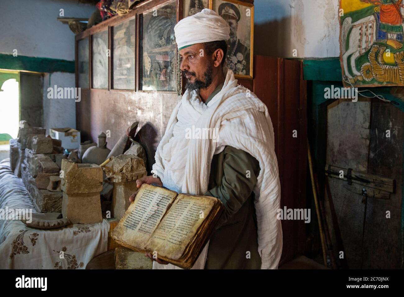 Orthodoxer Priester zeigt Bibel aus dem 14. Jahrhundert im Tempel von Yeha, älteste stehende Struktur in Äthiopien, Zentralzone, Tigray Region, Afrika Stockfoto