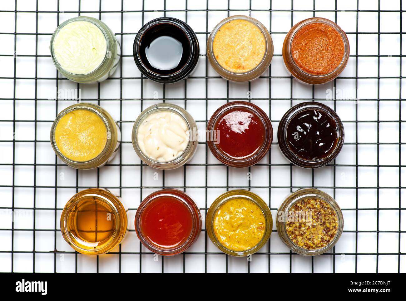 Große Sammlung von Saucen und gewürzten Aufstrichen in kleinen Gläsern wie Mayo Ketchup Senf Sojasoße und viele mehr Stockfoto