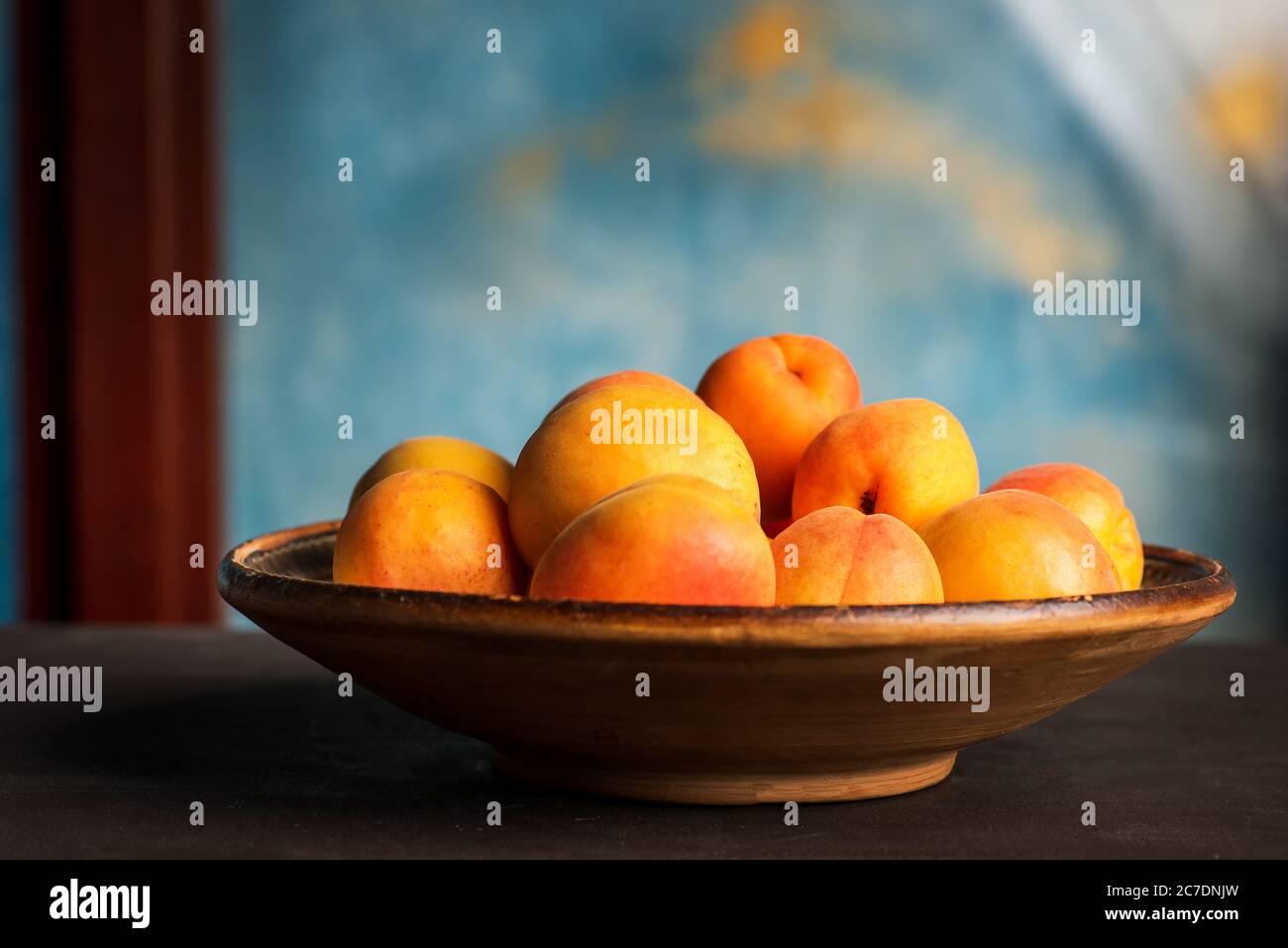 Reife Aprikosenfrucht isoliert auf einem Holztisch in einer Schüssel Nahaufnahme Stockfoto