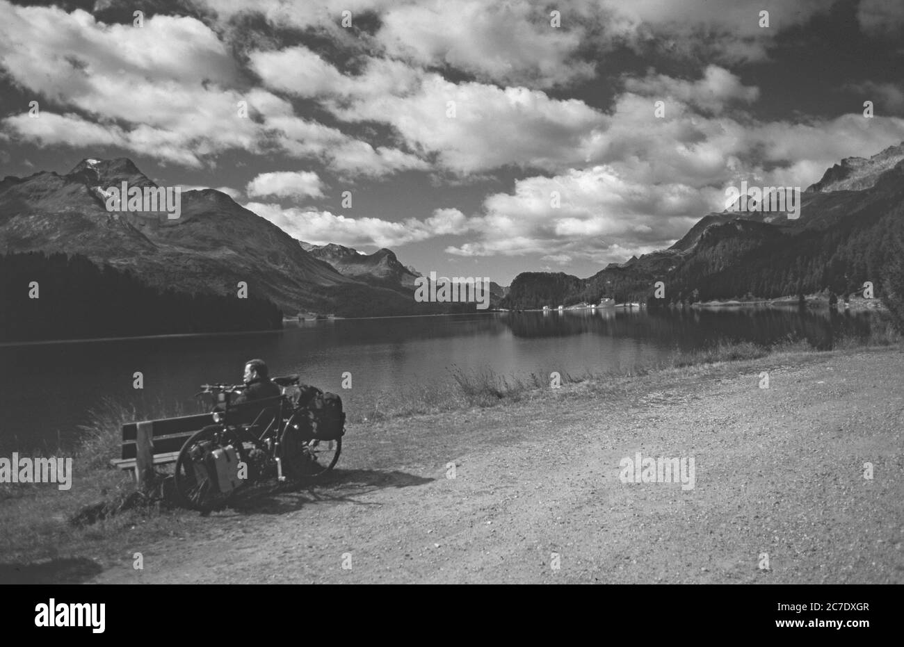 Ein Radfahrer rastet am Silvaplanersee mit Blick auf die Oberengadiner Berglandschaft am Silvaplaner See im Oberenga MACHT EIN Biker eine Pause Stockfoto