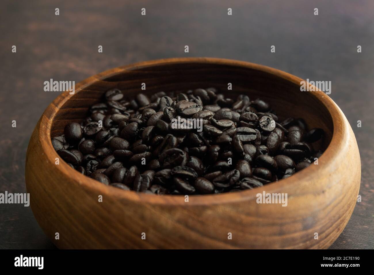 Dunkle geröste Kaffeebohnen in einer Holzschüssel Stockfoto