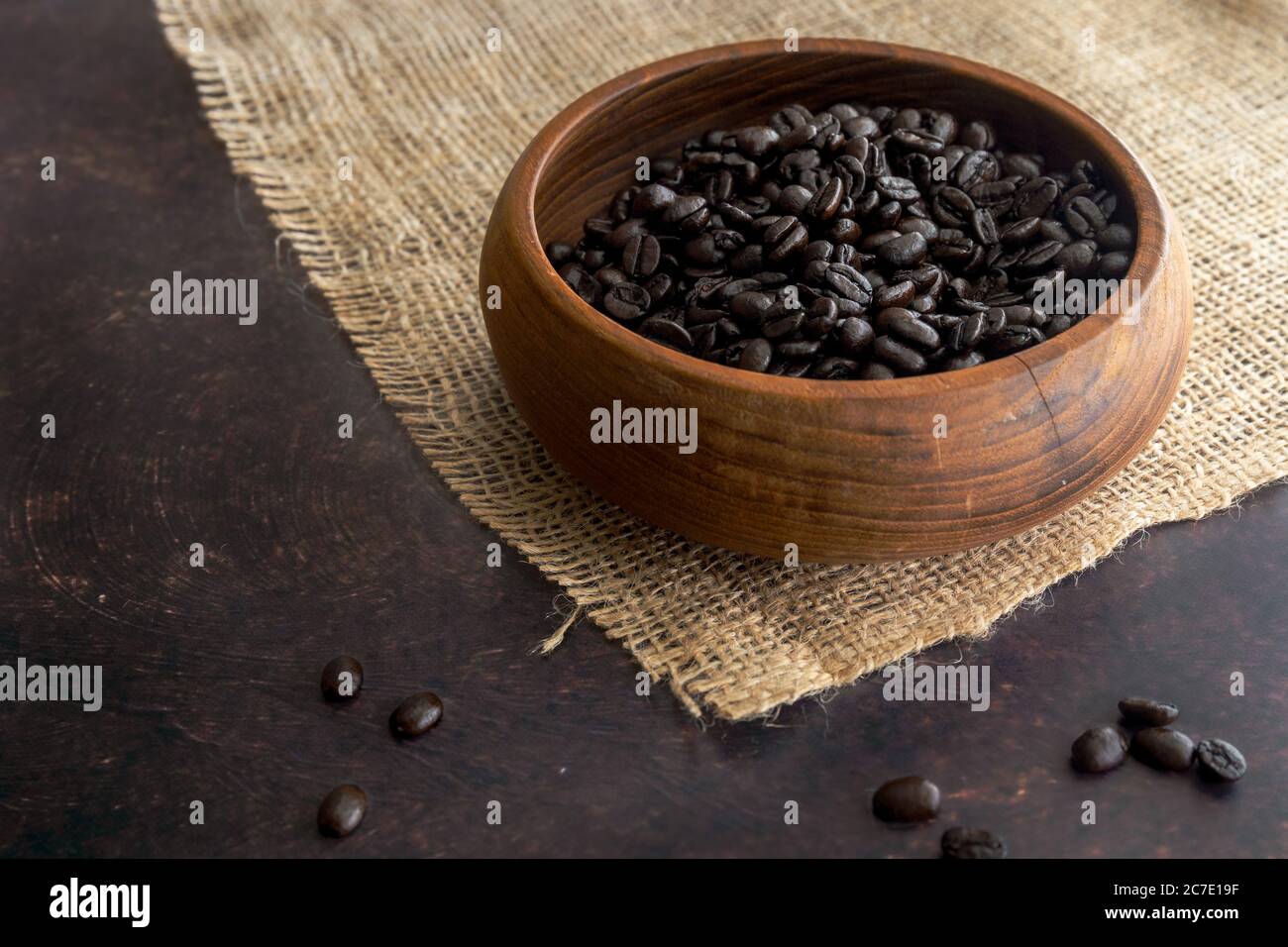 Dunkle Röstung Kaffeebohnen in einer Holzschüssel auf Burlap Stockfoto