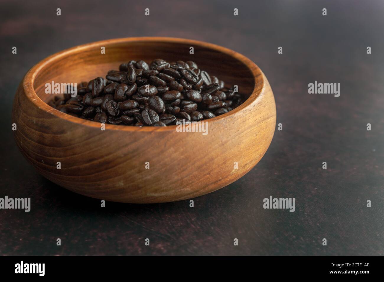Dunkle geröste Kaffeebohnen in einer Holzschüssel Stockfoto