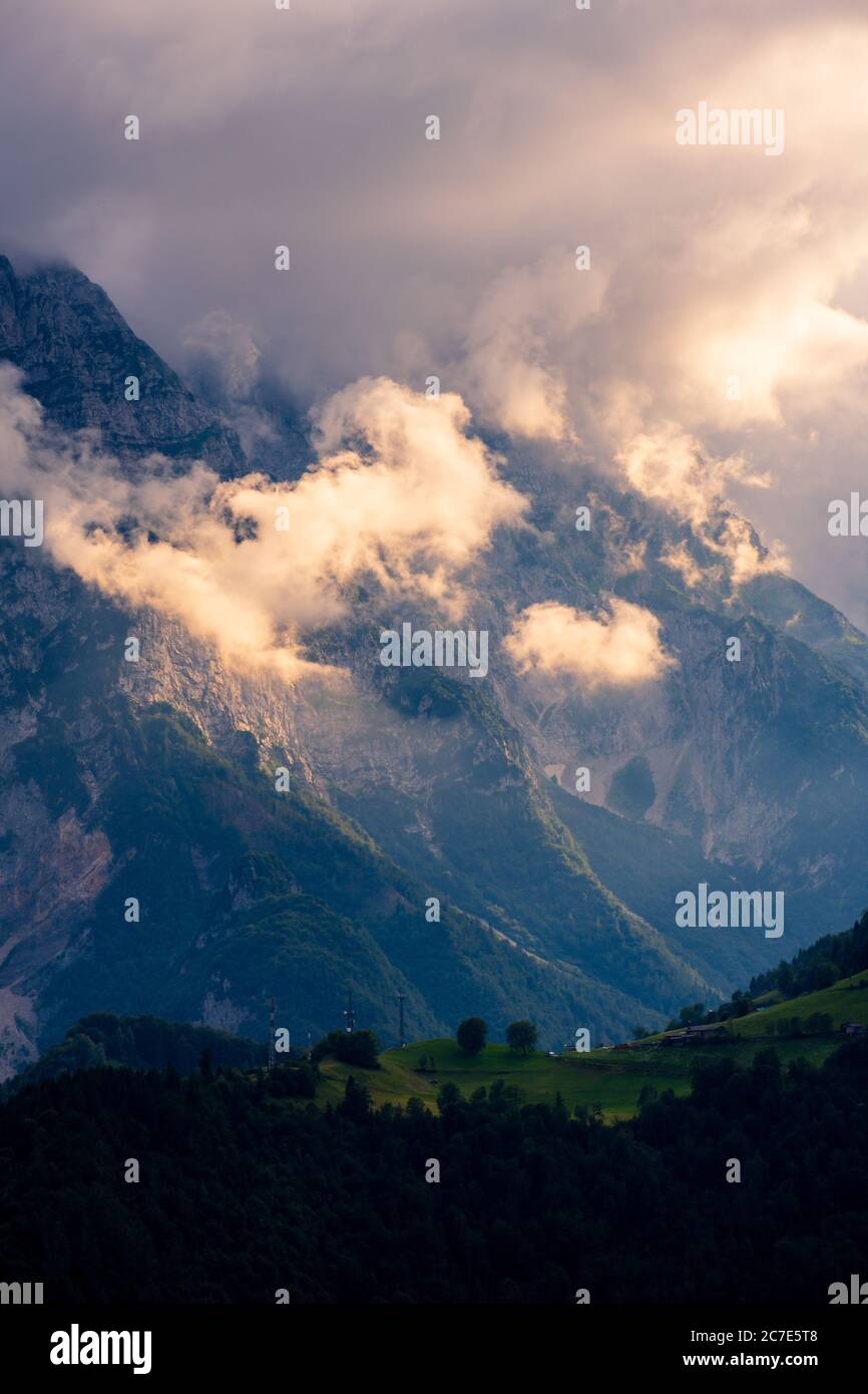 Vertikale Aufnahme von schönen Bergen in dicken Wolken und bedeckt Grüne Täler Stockfoto
