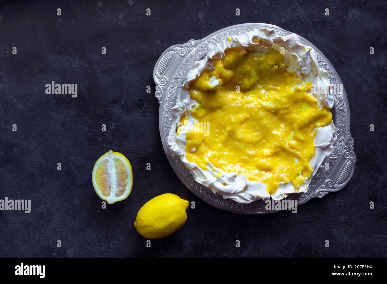Hausgemachte Baiser Basis für Kuchen Pavlova mit Zitronenquark. Knusprige Nachspeise auf schwarzem Hintergrund Stockfoto