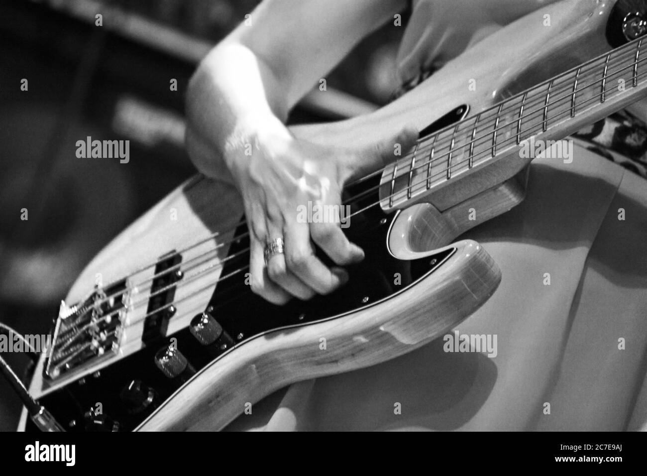 Horizontale Graustufenaufnahme einer Person, die eine E-Gitarre spielt Während eines Konzerts Stockfoto