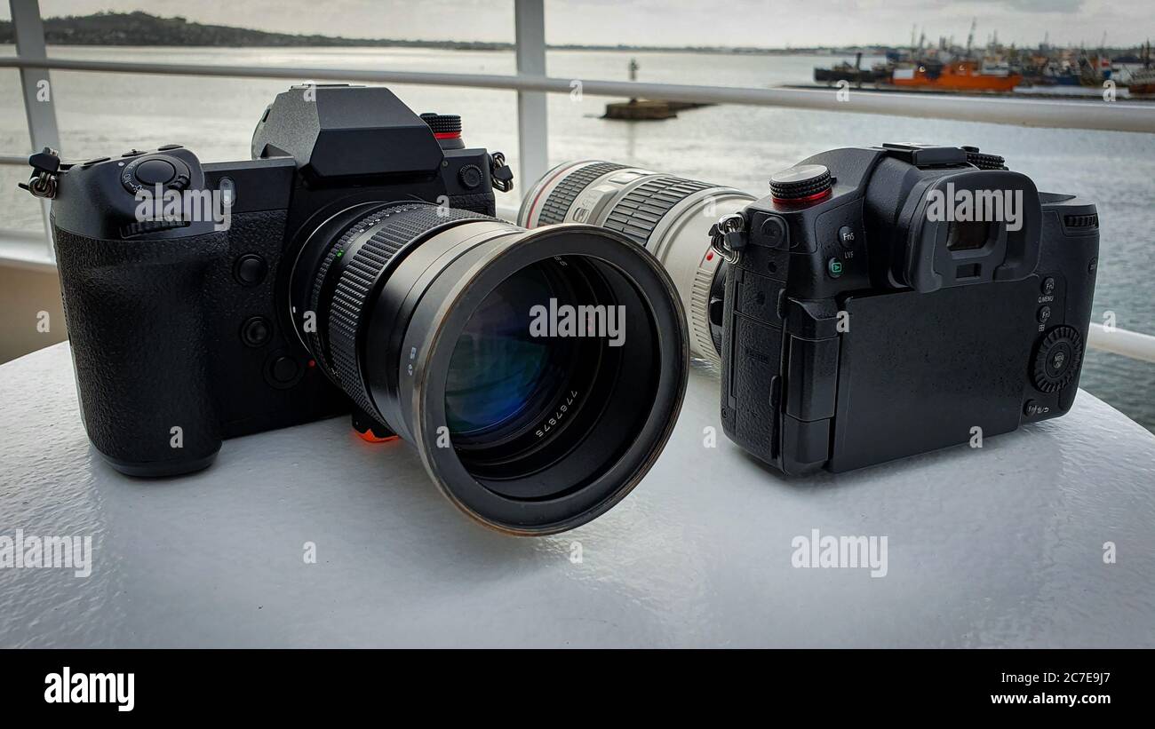 Zwei schwarze Kameras auf einem Boot mit Docks im Hintergrund Stockfoto