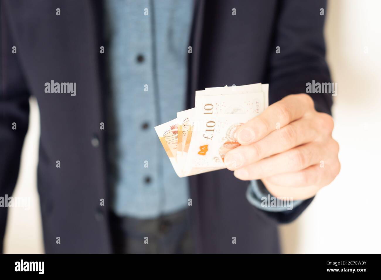 Person, die Bargeld, Banknoten, Geld zu Ihnen, für Sie, Geschenk, hier ist etwas Geld, nehmen Sie es, Hand, Hände, zahlen, begleichen, überweisen, Schulden Stockfoto